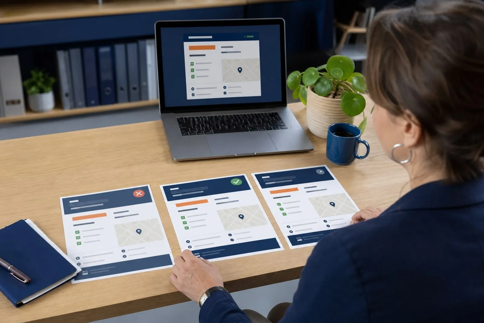 Dirigeante comparant les informations locales de son entreprise entre plusieurs fiches et un ordinateur
